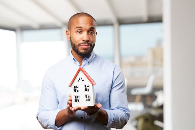 Real estate agent holding a house model with both hands