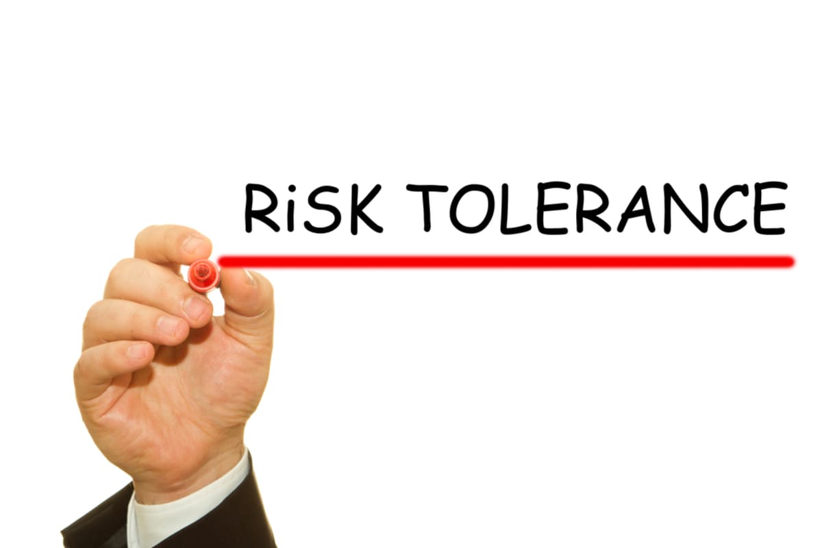 A hand writing the words “risk tolerance