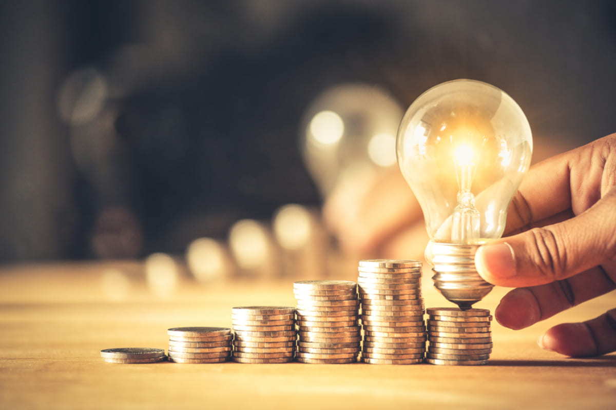 A lightbulb on stacks of coins, creative real estate investing strategies concept