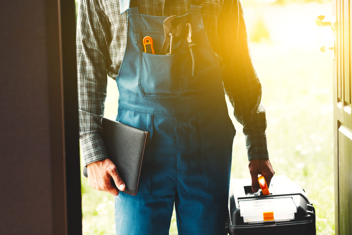 A maintenance worker with a tool kit and a folder