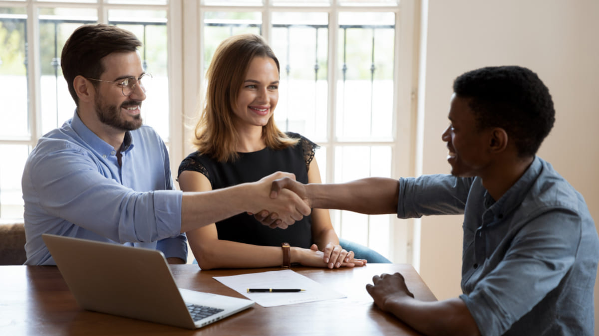 A property manager shakes hands with tenants, a happy resolution for eviction prevention