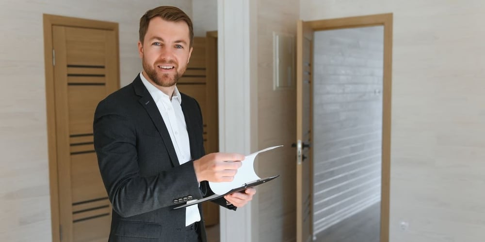 A real estate agent with a clipboard inside a home