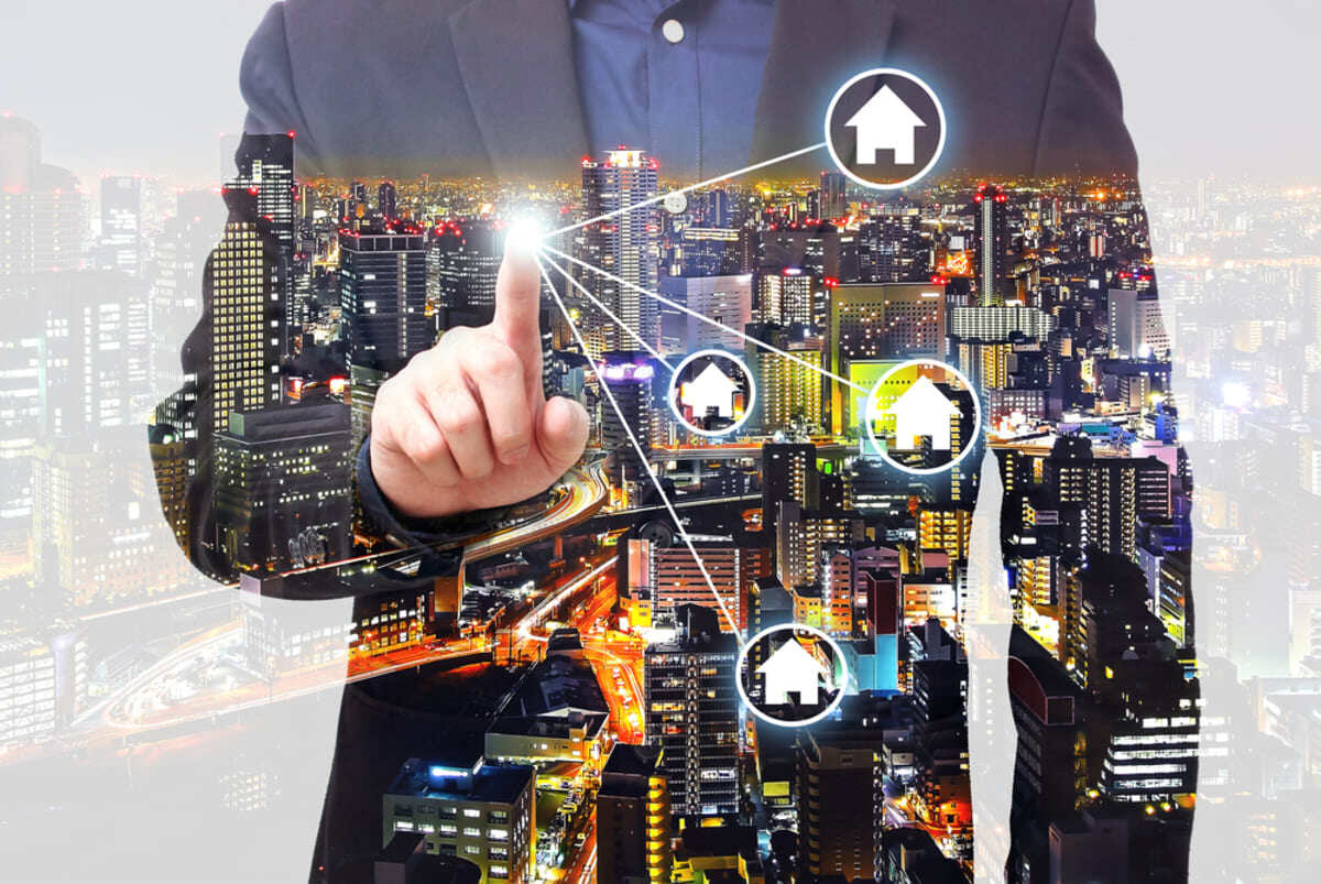 Man in a suit tapping on a web of houses