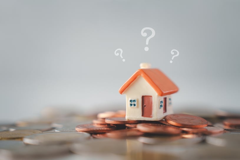 Question mark and house model on coins