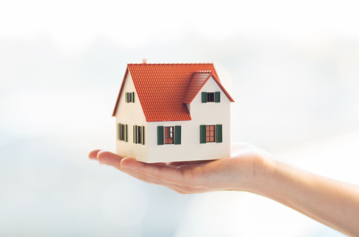 Someone holding a model house in their hand