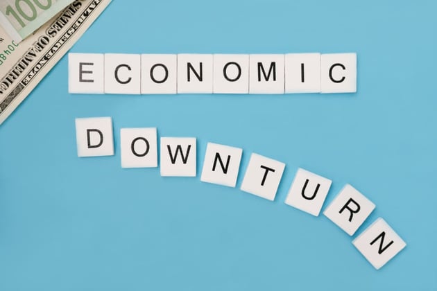 The phrase economic downturn is spelled out in wooden tiles