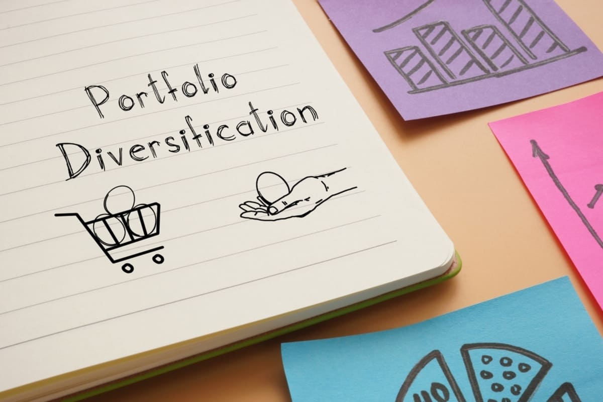 The words portfolio diversification written in a notebook next to a drawing of eggs in a basket