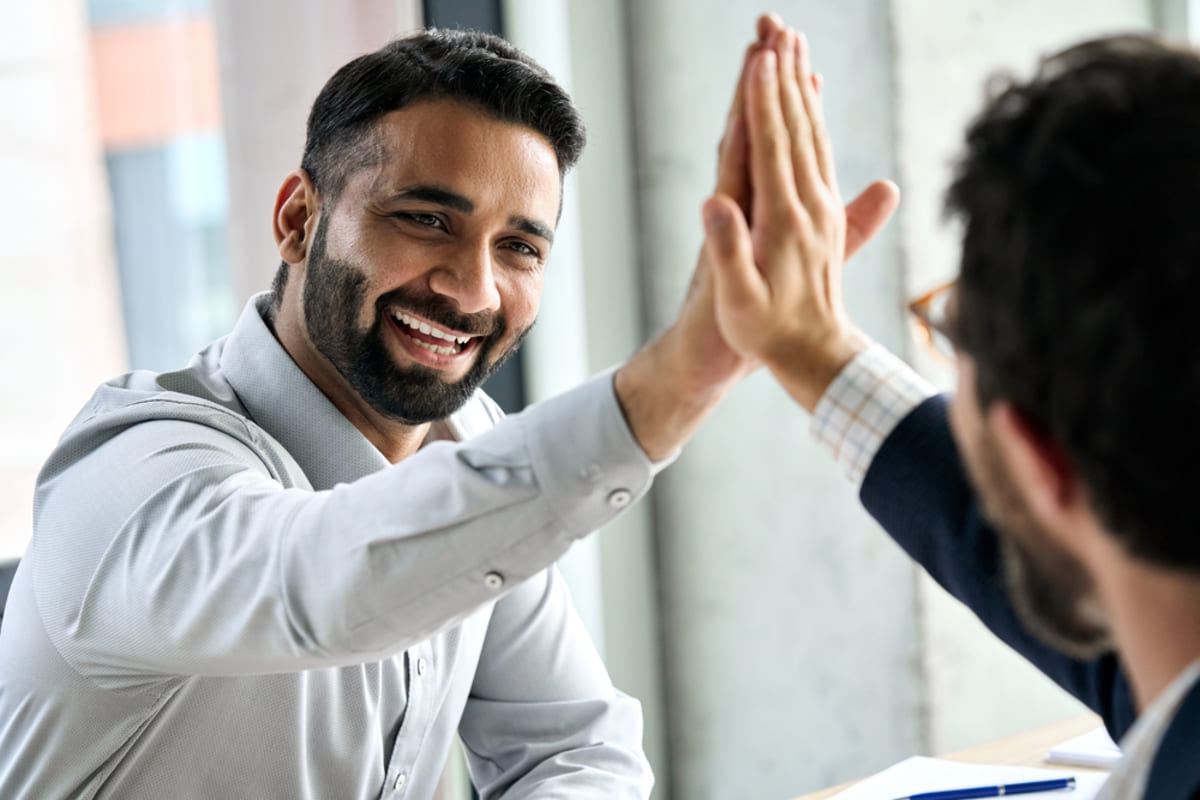 Two people high-fiving in a business setting