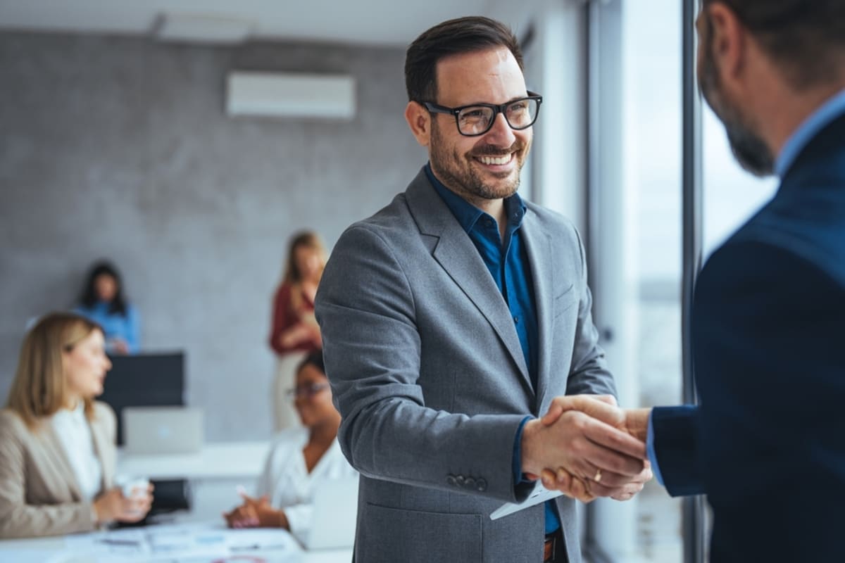 Two people shaking hands in an office