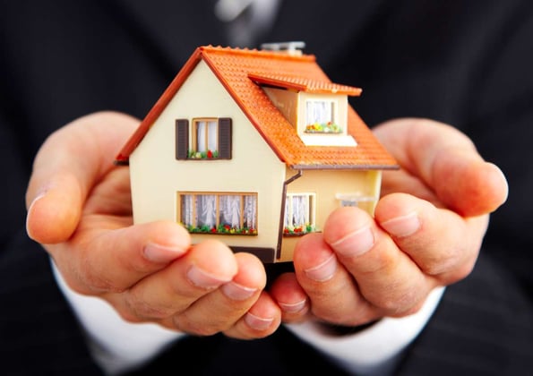 Property manager holding a small house model in his hands