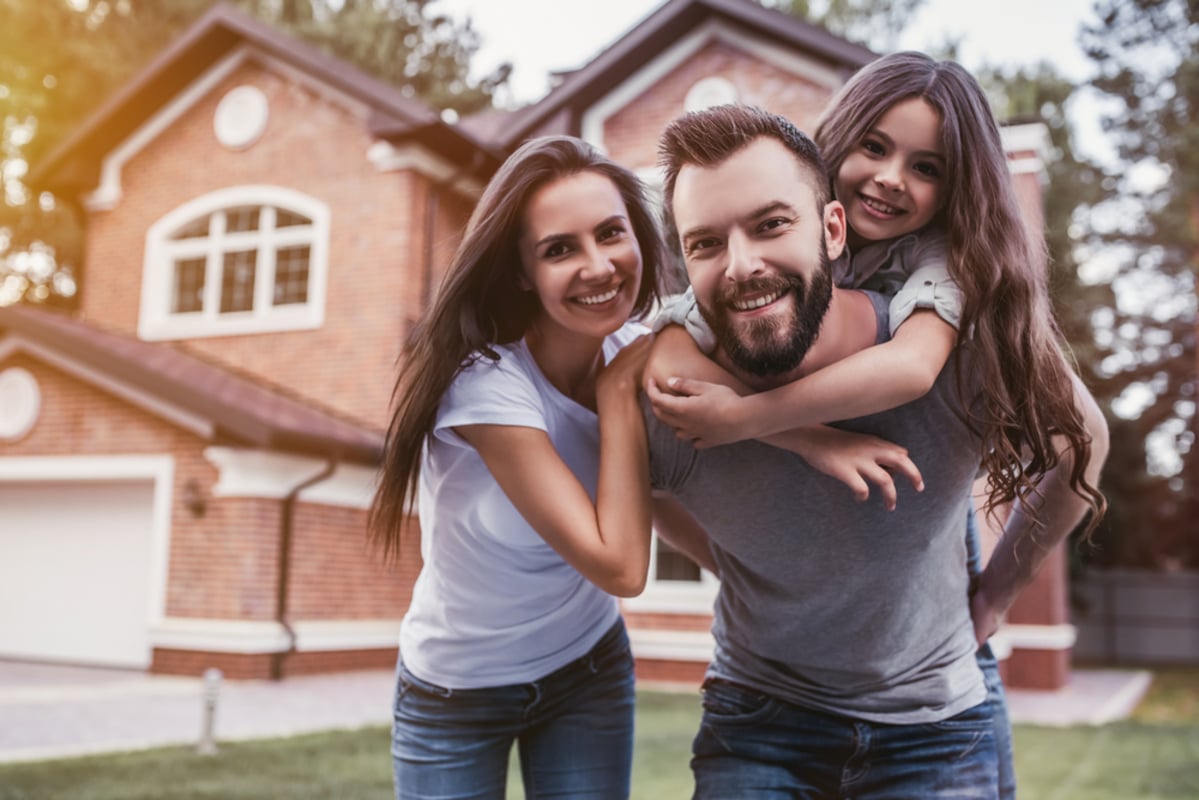 Happy family is standing near their modern house (R)