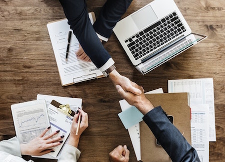 Close-up of people shaking hands, compliance with Michigan landlord-tenant laws concept. 