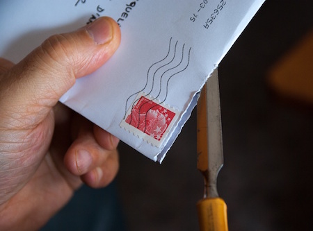 Hand holding a stamped envelop, Michigan security deposit law concept. 