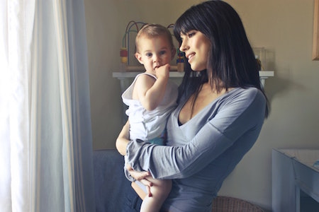 woman-holding-baby-looking-outside