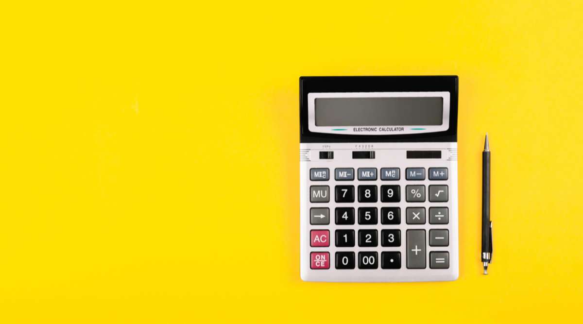 Calculator on a yellow background, calculating rental property ROI concept. 