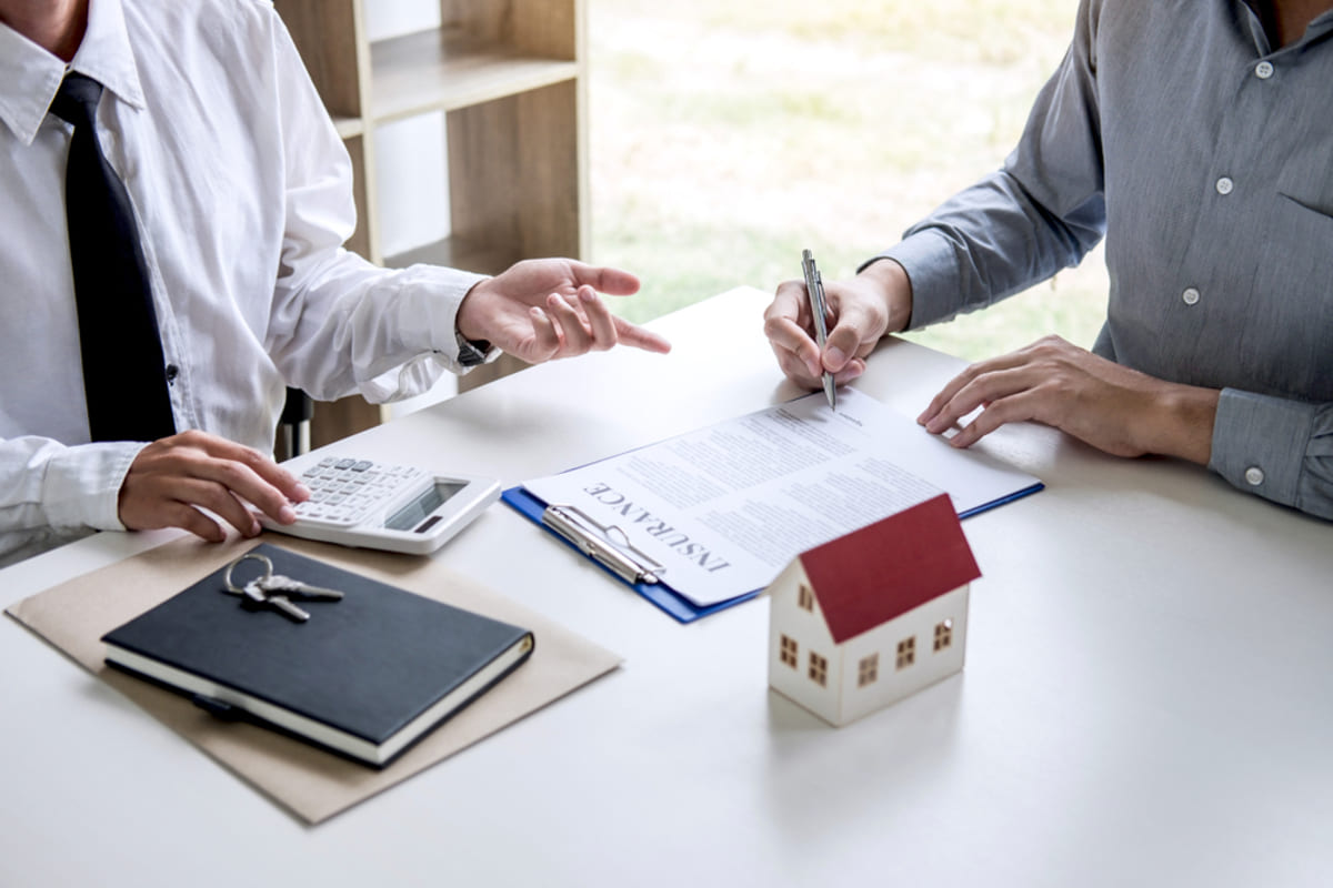 Someone filling out a document labeled insurance with a professional