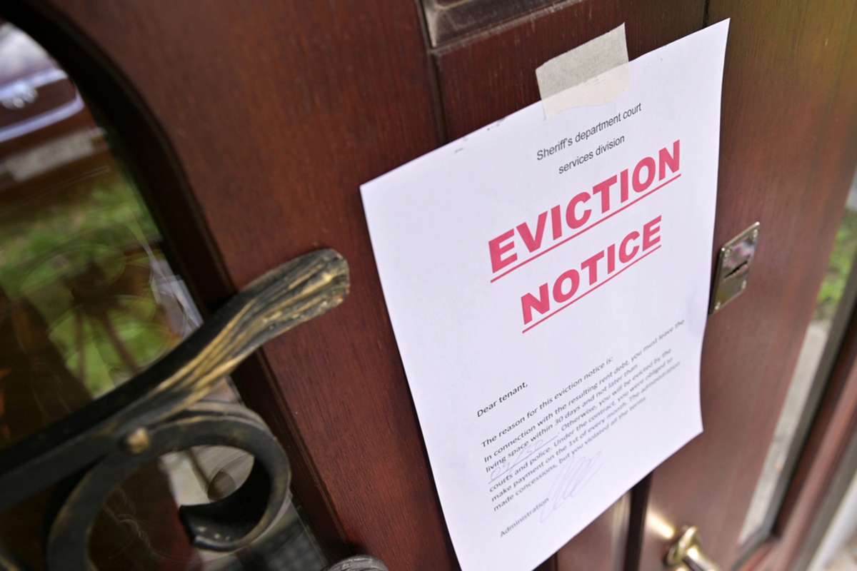 A notice of eviction taped to a door, Michigan eviction laws concept. 