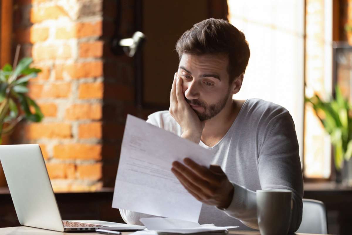 A stressed tenant reads a late rent notice, Detroit property managers concept