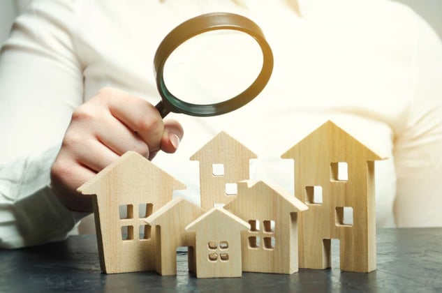 wooden house models with a magnifying glass