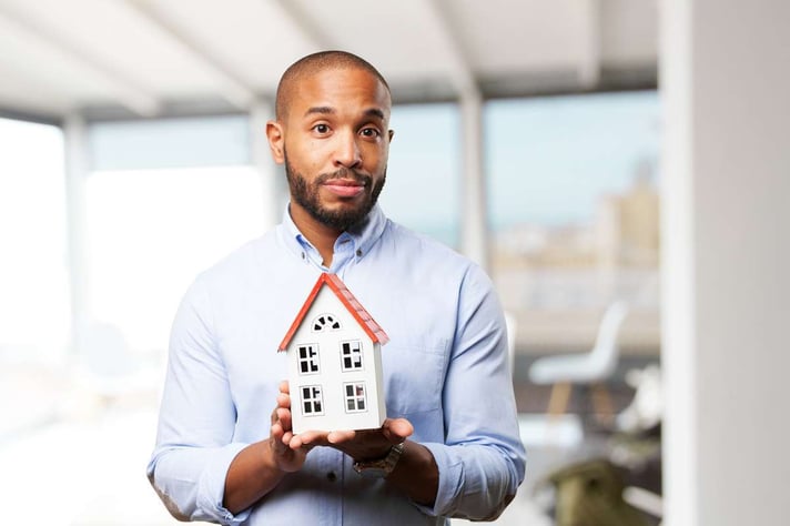 Black businessman with toy house