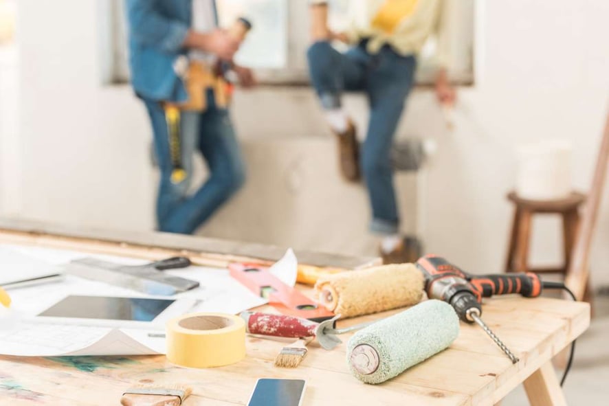 Close-up view of tools and digital devices on table during house repairment