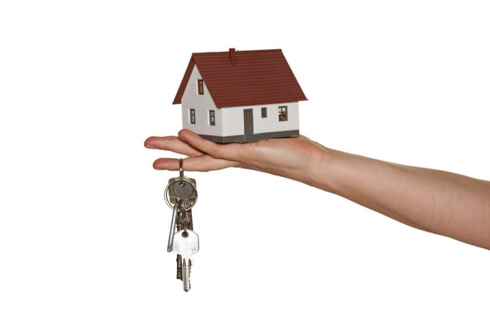 A house and keys in the palm of a hand, turnkey investing benefits concept. 