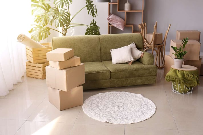 Furniture with moving boxes and belongings in room, Detroit investment portfolio concept.