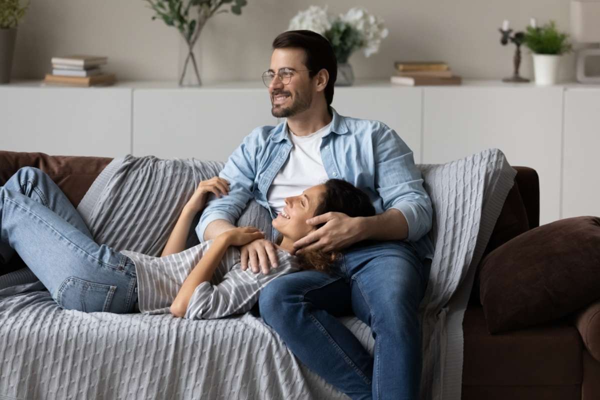 Happy dreamy couple relaxing on couch