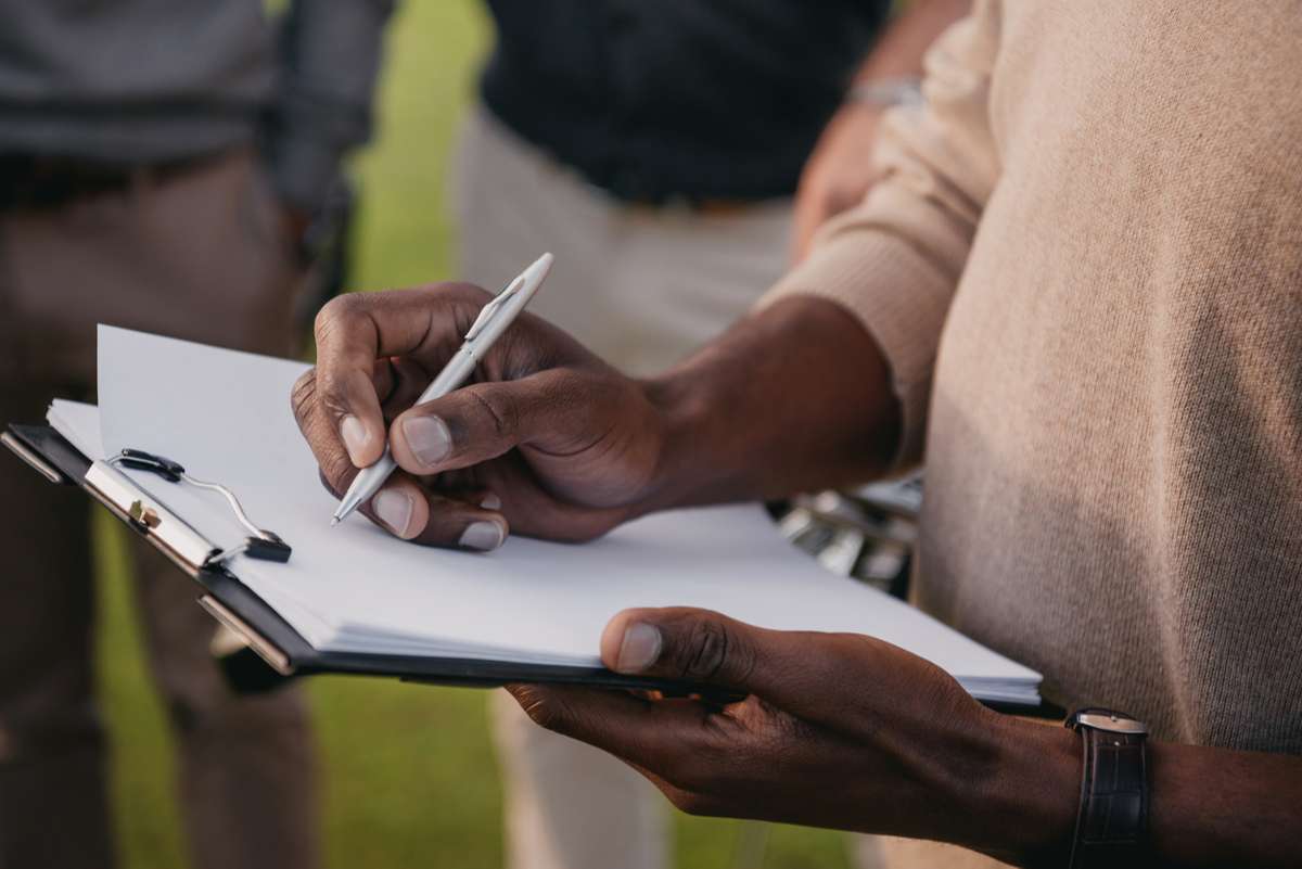 Man writing on paper in clipboard-1