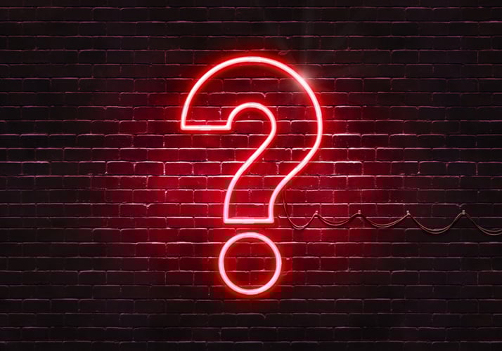 Light shaped as a question mark over a brick wall