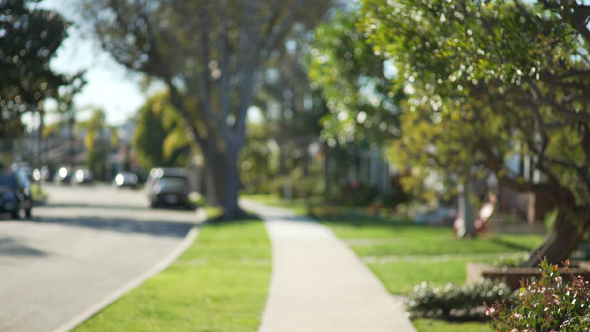 Quiet street scene of the sidewalk and idyllic homes in a suburban neighborhood