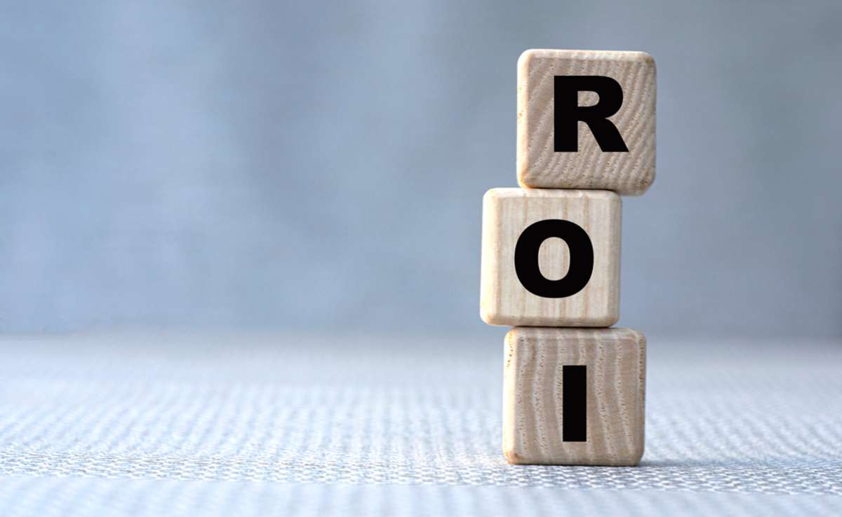 ROI (Return On Investment) concept word on wooden cubes on a gray background