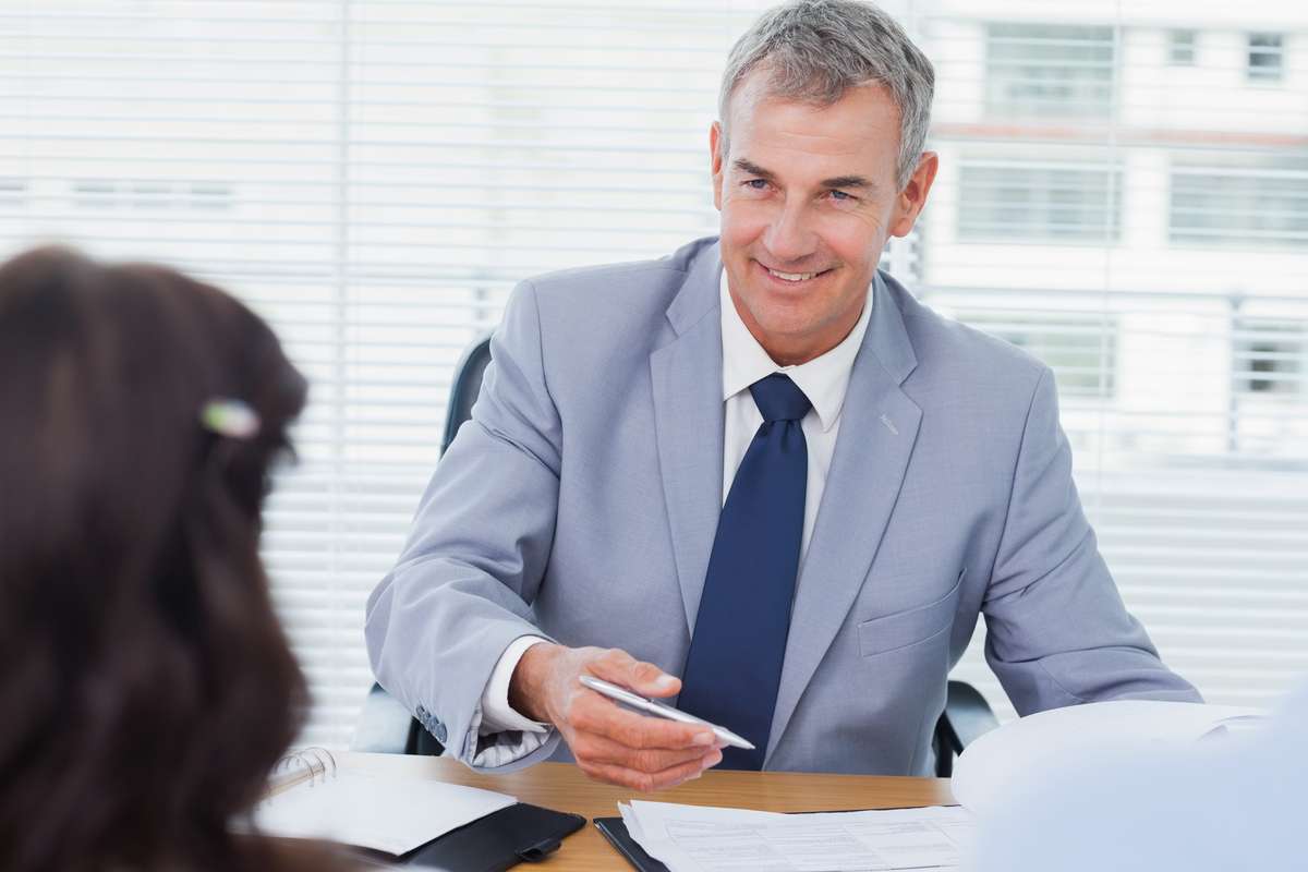 Smiling real estate agent completing contract with couple