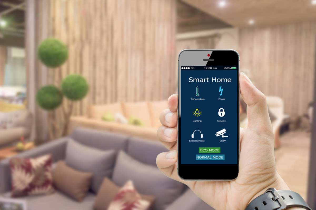 hands holding smart phone with app smart home on blurred living room as backgrounds
