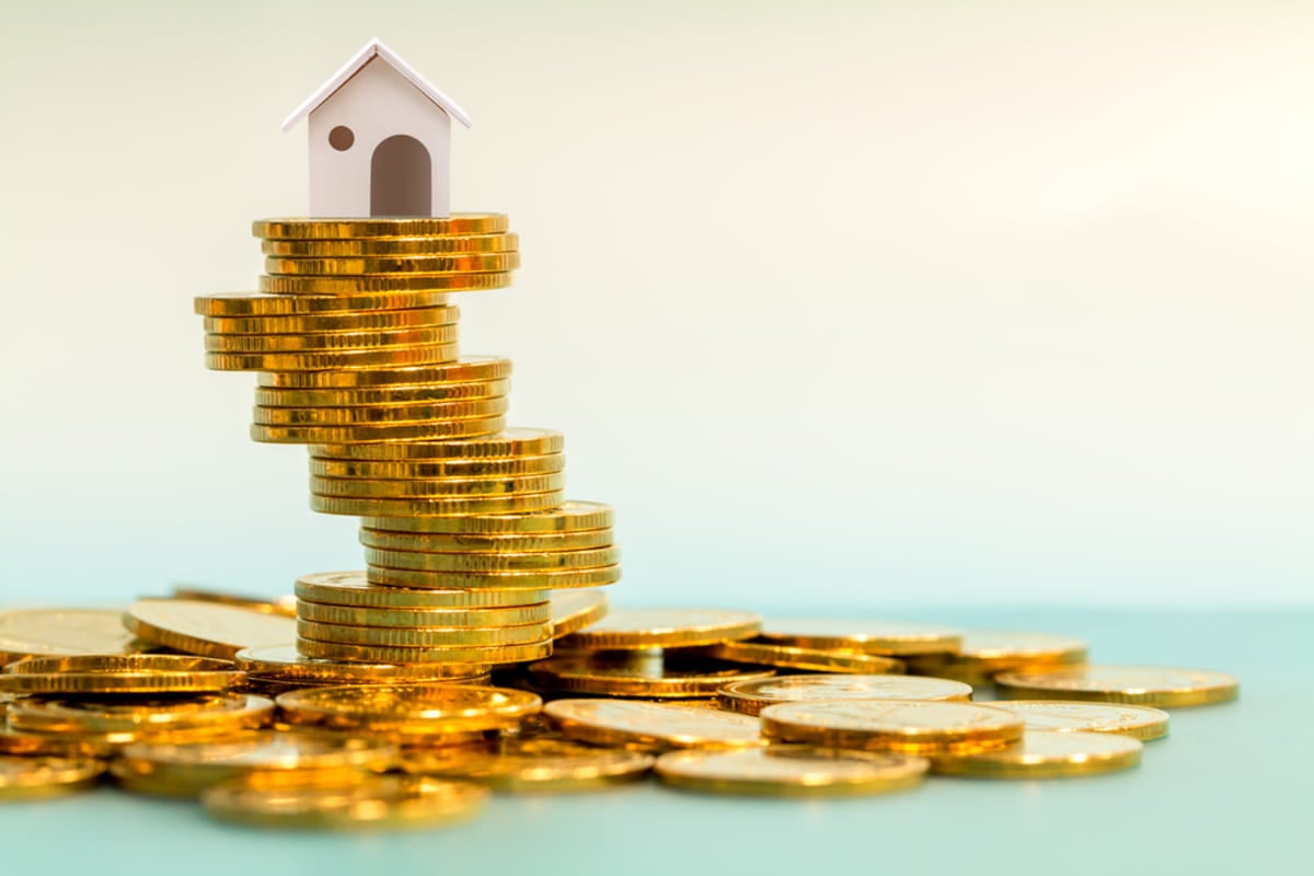 A small model house on top of coins