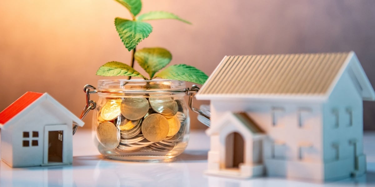 Coins in a jar next to small houses