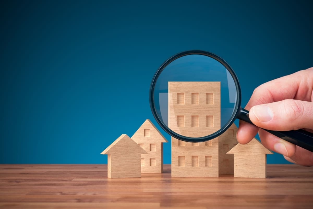 Magnifying glass on wooden models of properties
