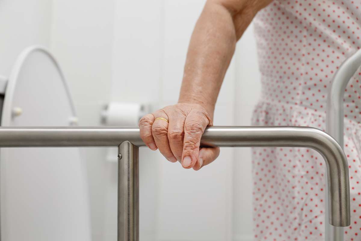 Elderly holding a railing for support