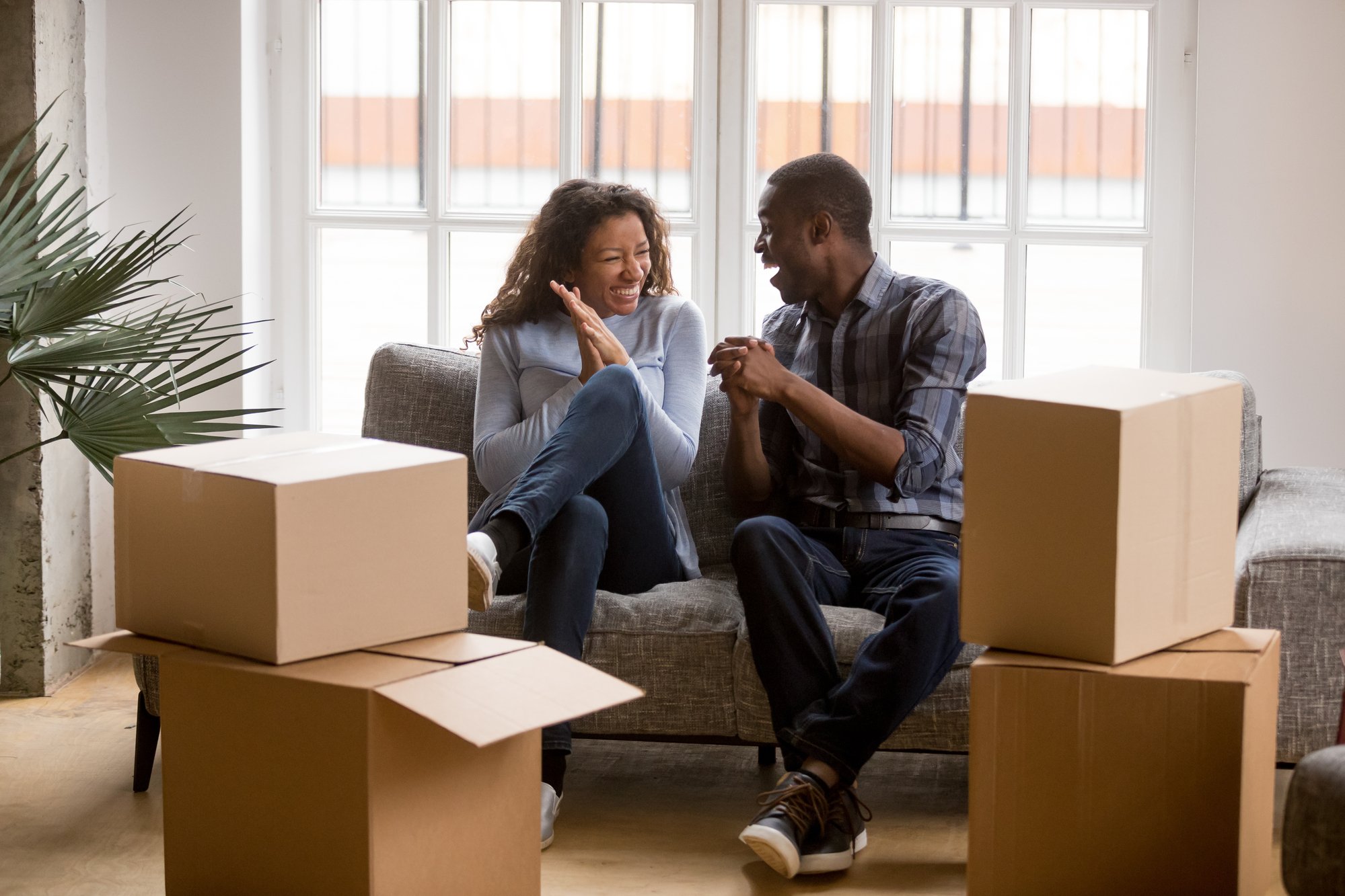 Couple smiling on a couch in new home