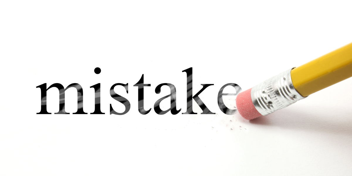 The word mistake written with a pencil on white paper-1