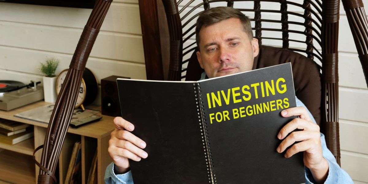 2 Man reads investing for beginners book at home