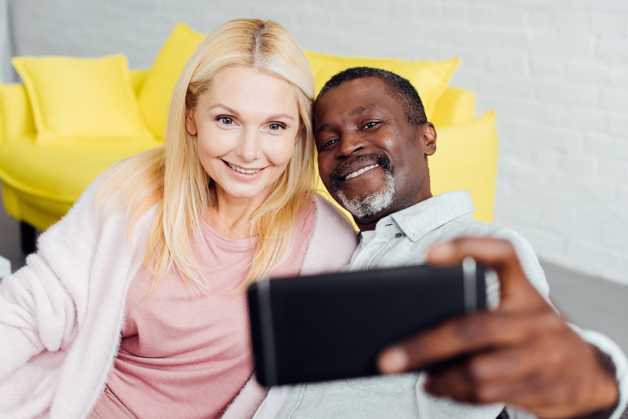 Old couple holding cellphone taking a selfie