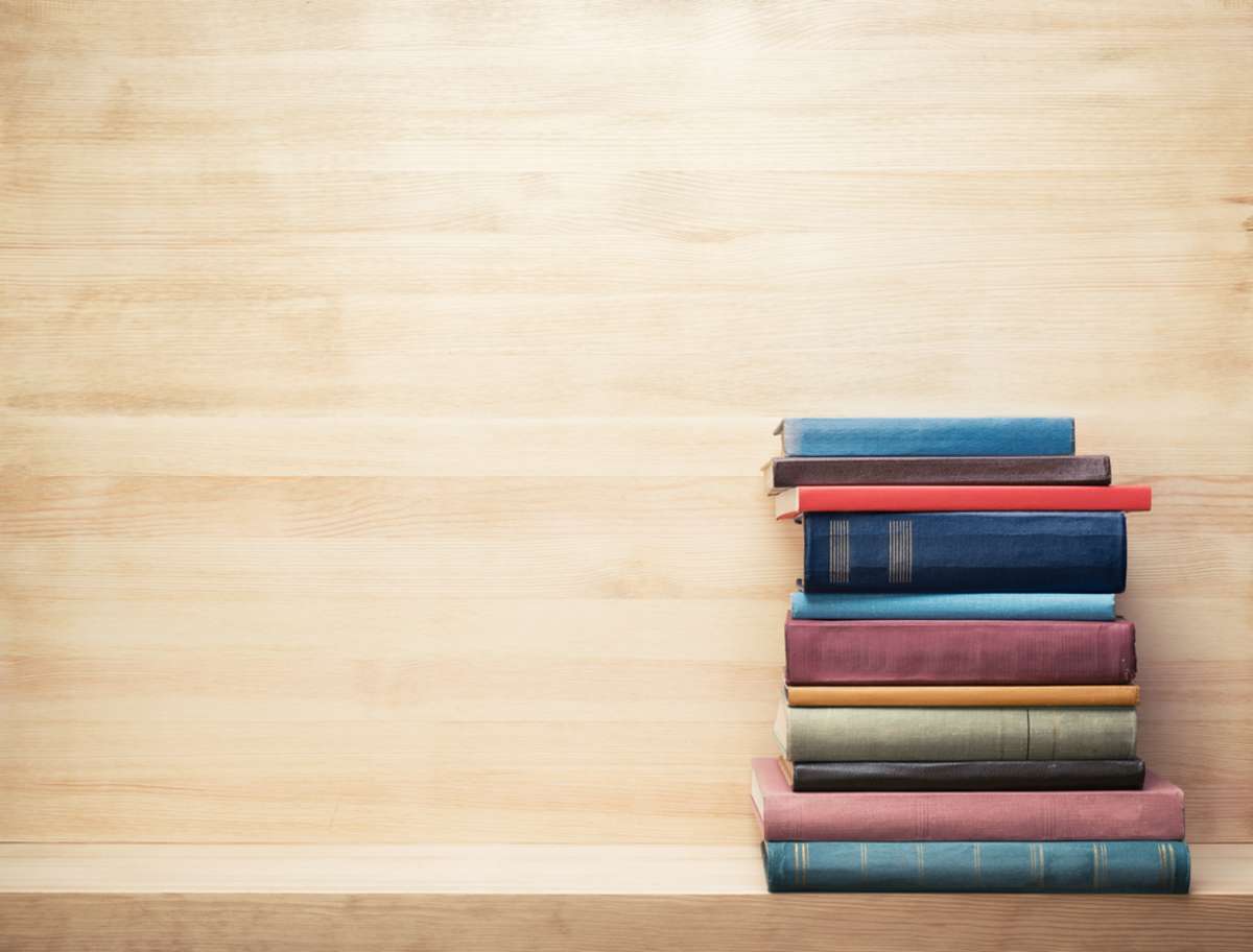 A stack of books on a shelf, real estate investing books concept