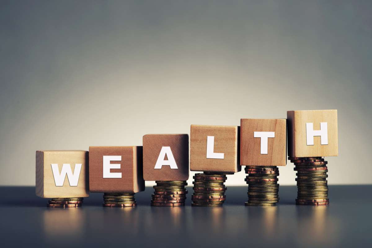 Wealth spelled in blocks with stacked coins, turnkey investing benefits concept