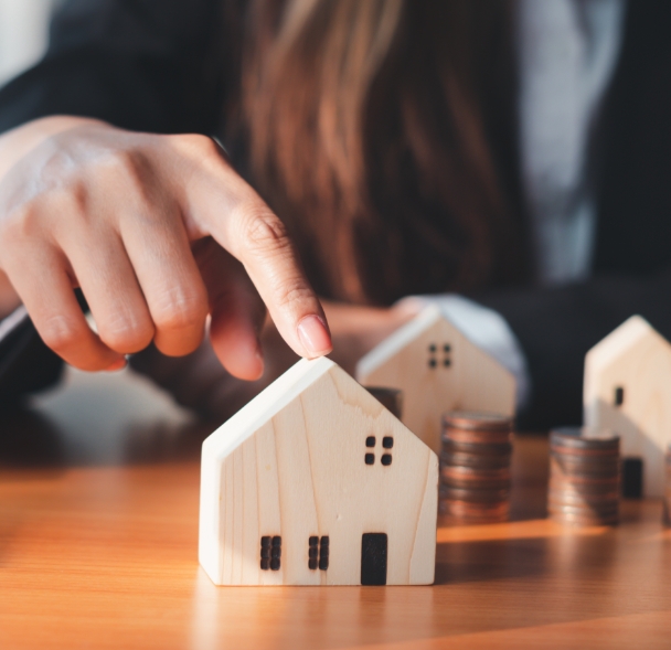 Finger touching house on table