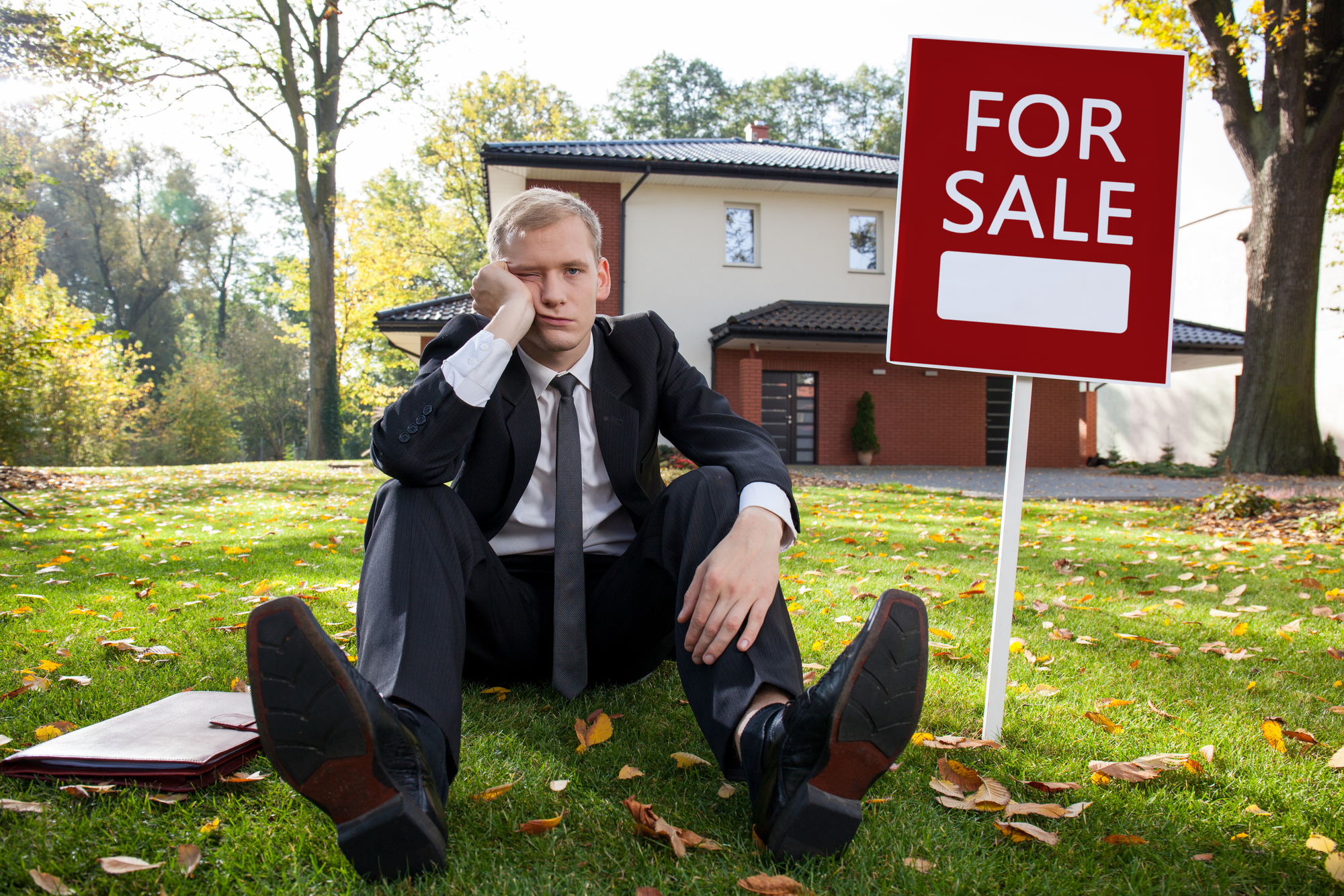 A sad property manager sitting on the grass